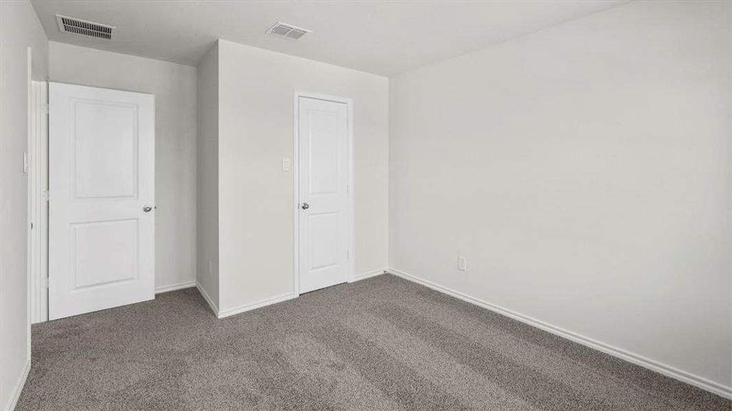 The property features a room with light grey carpet, white walls, and two white panel doors