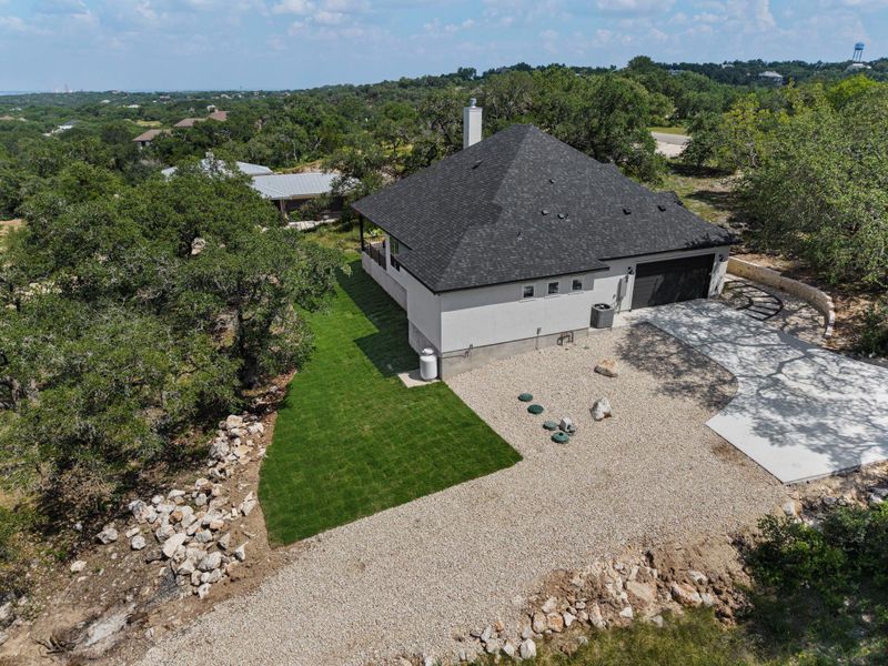 A well-maintained residence with a classic black roof and an inviting gravel driveway.