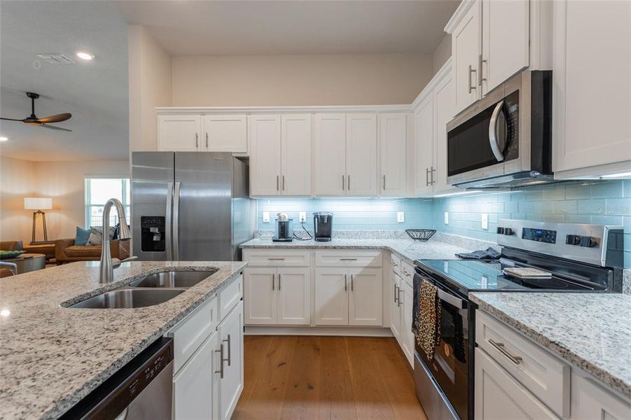 under counter lighting and glass tile backsplash