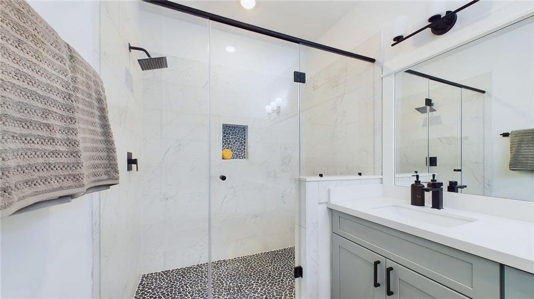 Primary bathroom features a shower with semi-frameless glass shower door