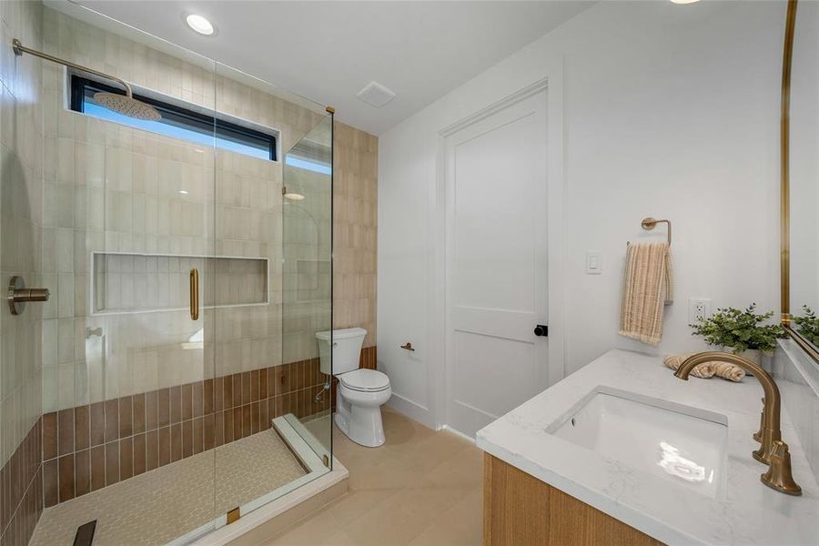 Contemporary bathroom featuring a spacious glass-enclosed shower with a transom window and recessed shelving