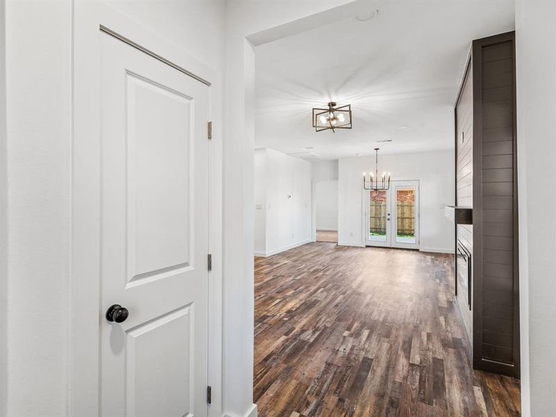 Hallway featuring dark wood-style floors and a chandelier