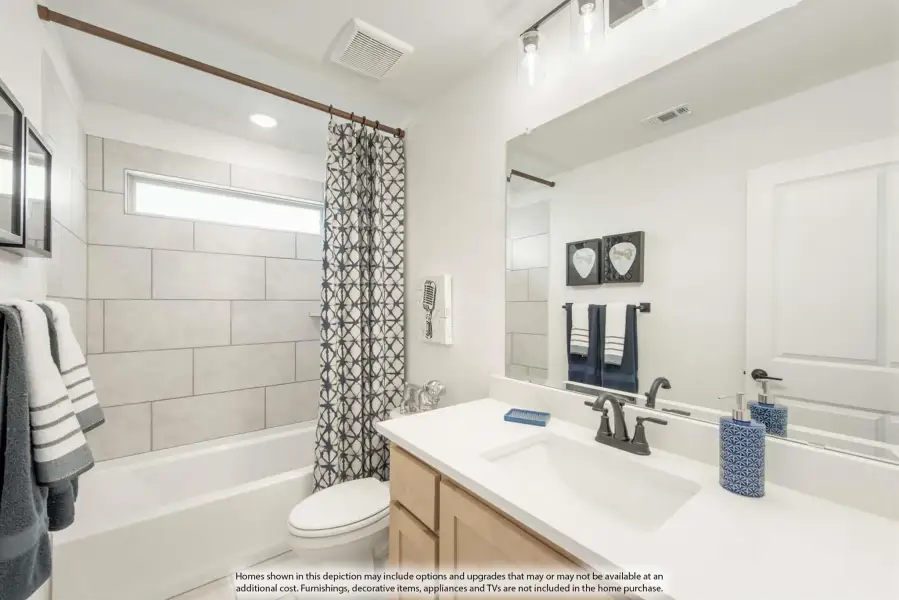 Bathroom with tiled tub-shower combo, wood vanity, white countertop, and large mirror