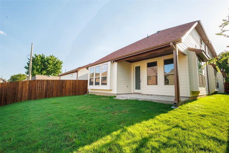 Rear view of property with a shingled roof and a patio area