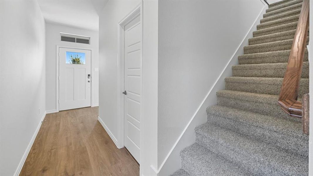 Staircase with baseboards and wood finished floors
