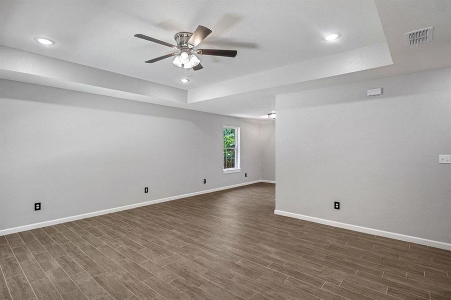 Spare room featuring a tray ceiling, ceiling fan, recessed lighting, and dark wood finished floors Spare room featuring a tray ceiling, ceiling fan, recessed lighting, and dark wood finished floors