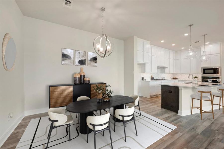 Dining area with light wood-style floors and hanging lights