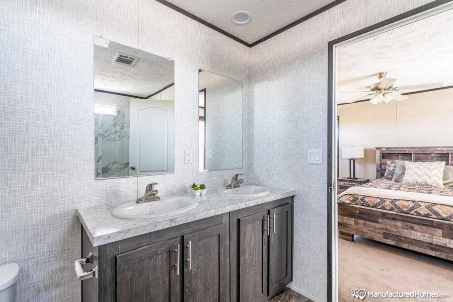 A well-appointed bathroom vanity with dual sinks, framed by crisp, textured walls.