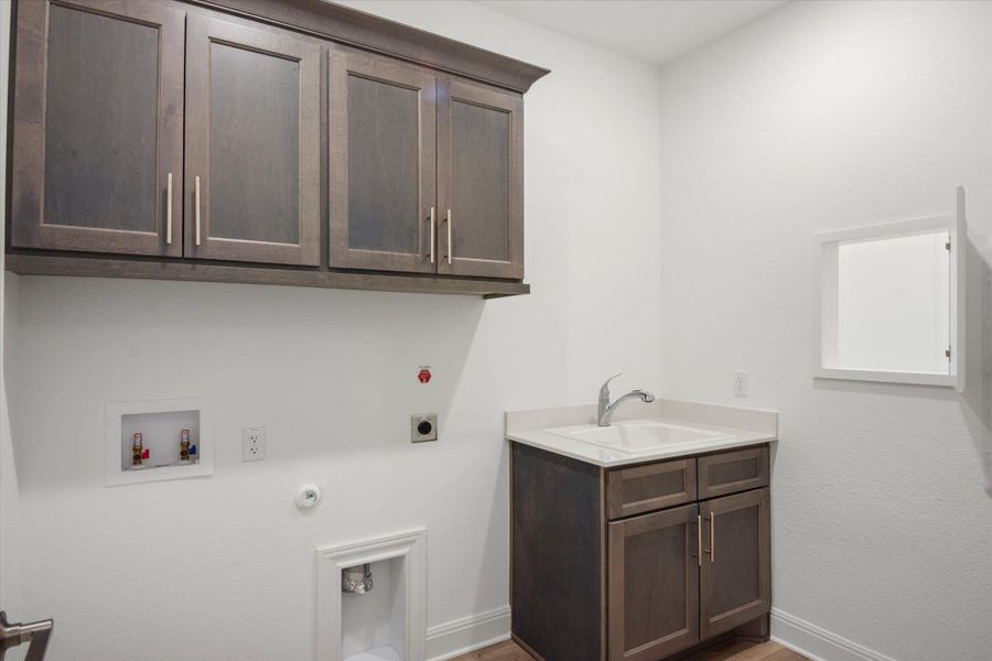 Laundry Room with Sink , cabinets and a Laundry chute from the primary bathroom