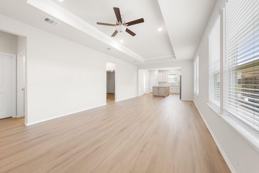 A spacious living area with light wood flooring flows into a well-appointed kitchen, ideal for entertaining. A spacious living area with light wood flooring flows into a well-appointed kitchen, ideal for entertaining.