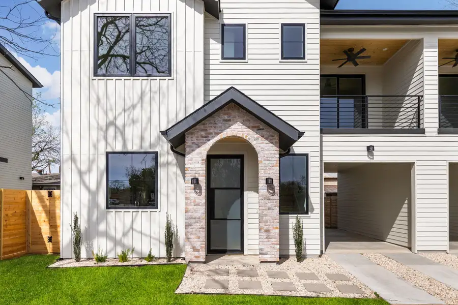 View of front facade with board and batten siding, a balcony, and a ceiling fan