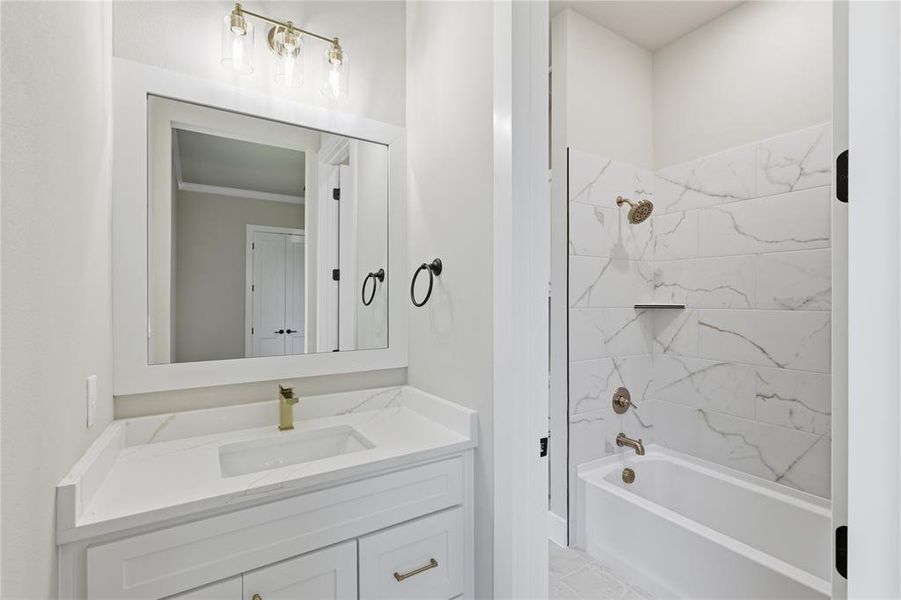 Bathroom featuring a white vanity with gold-tone hardware, a rectangular undermount sink, and a white countertop