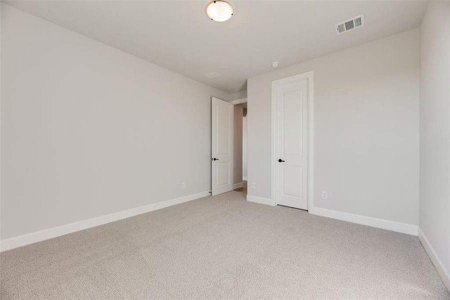 Empty room with carpet and baseboards Empty room with carpet and baseboards