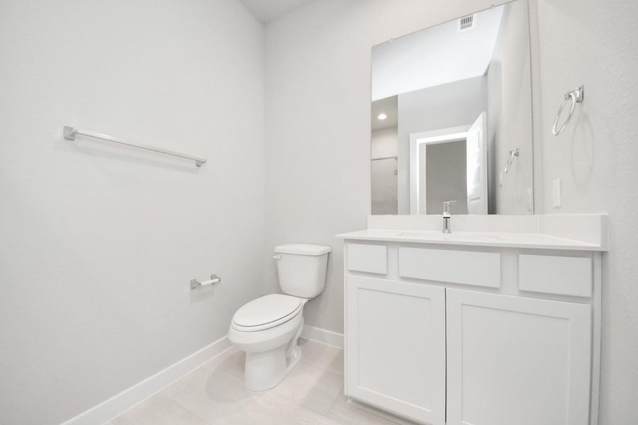 Experience sophistication in the guest suite bathroom, where tile flooring complements a walk-in shower with tile surround. Light wood cabinets complete with a beautiful light countertop, enhances the space for a truly inviting ambiance. Experience sophistication in the guest suite bathroom, where tile flooring complements a walk-in shower with tile surround. Light wood cabinets complete with a beautiful light countertop, enhances the space for a truly inviting ambiance.