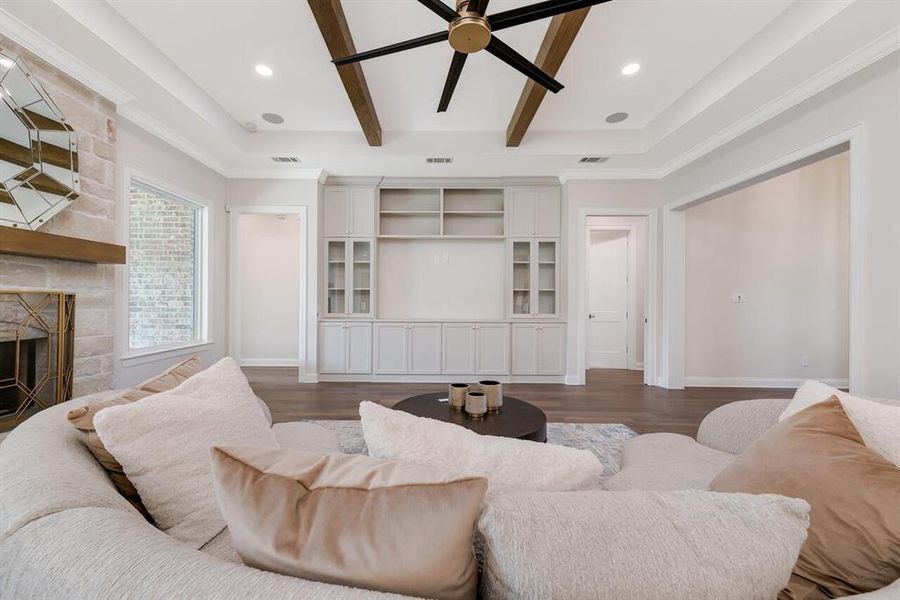 Living area with a fireplace, dark wood-type flooring, ceiling fan, recessed lighting, and beamed ceiling Living area with a fireplace, dark wood-type flooring, ceiling fan, recessed lighting, and beamed ceiling