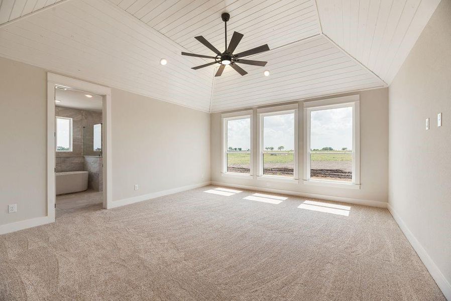Empty room with ceiling fan, wooden ceiling, and light colored carpet