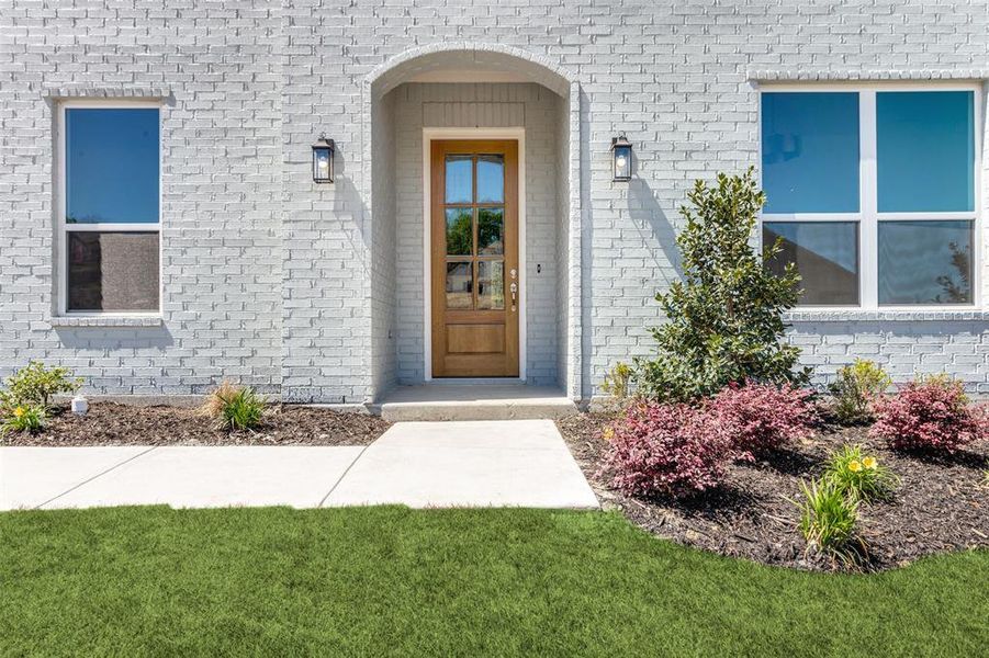 View of exterior entry featuring a lawn