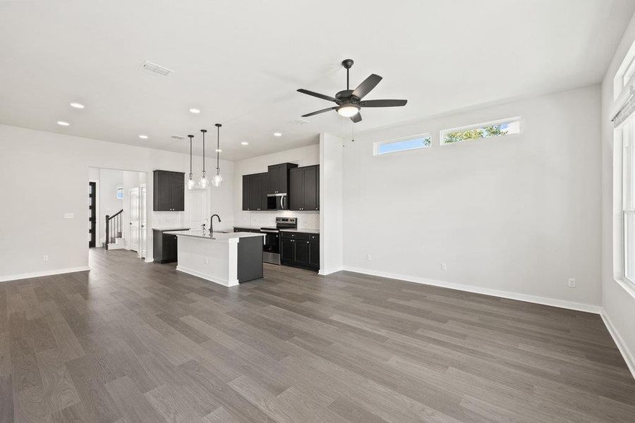 Unfurnished living room with dark wood-type flooring, recessed lighting, and a ceiling fan
