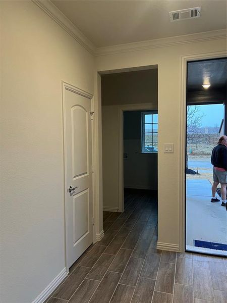 Corridor featuring crown molding and wood finish floors Corridor featuring crown molding and wood finish floors