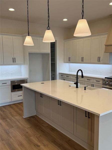 Vinyl plank floors offset kitchen colors wonderfully.  Microwave drawer and an island with extra storage space under the bar seating area.