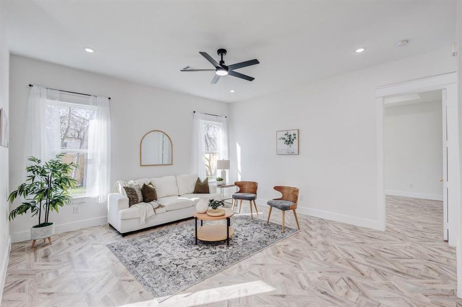 Living room featuring ceiling fan and light parquet floors