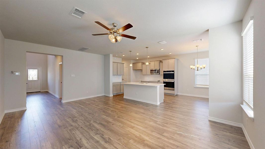 Open concept living area with light wood-style flooring, a ceiling fan, and recessed lighting