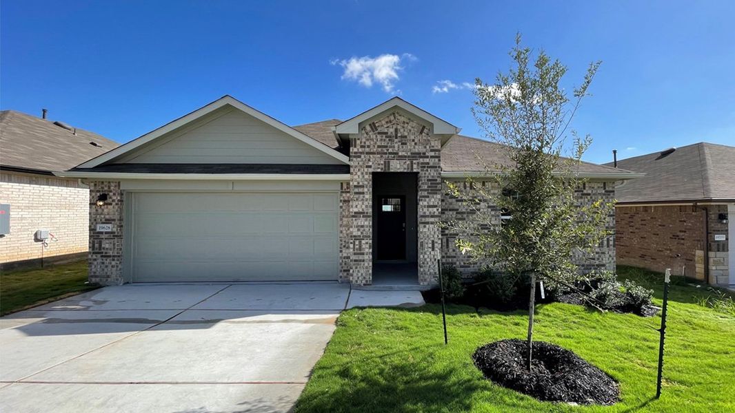 Front exterior of a new home in Carillon, Manor, TX, highlighting curb appeal (Image 1). Front exterior of a new home in Carillon, Manor, TX, highlighting curb appeal (Image 1).