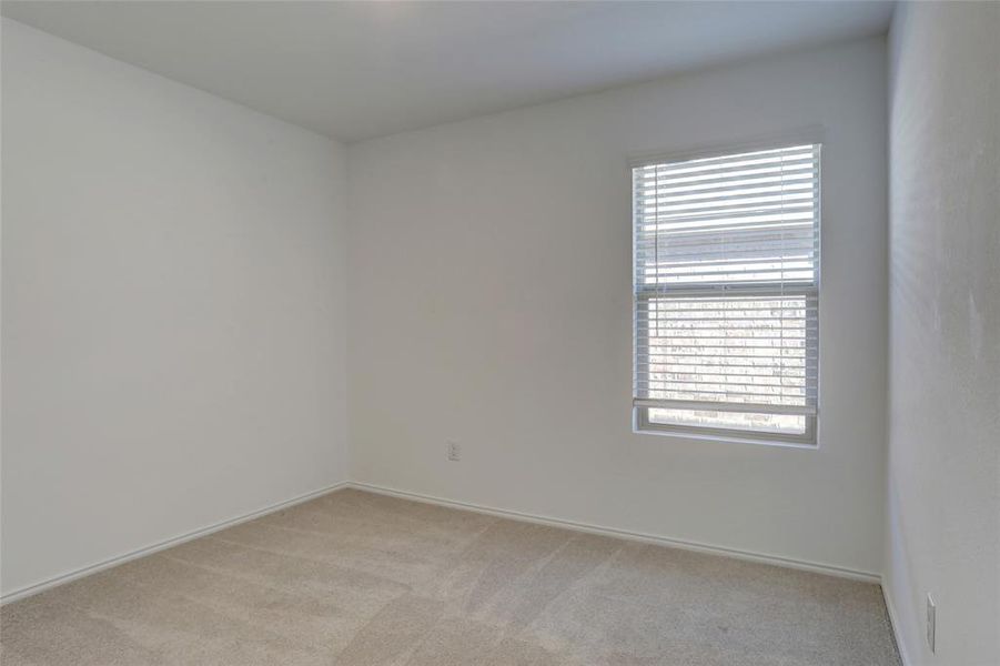 Spare room with light carpet and baseboards