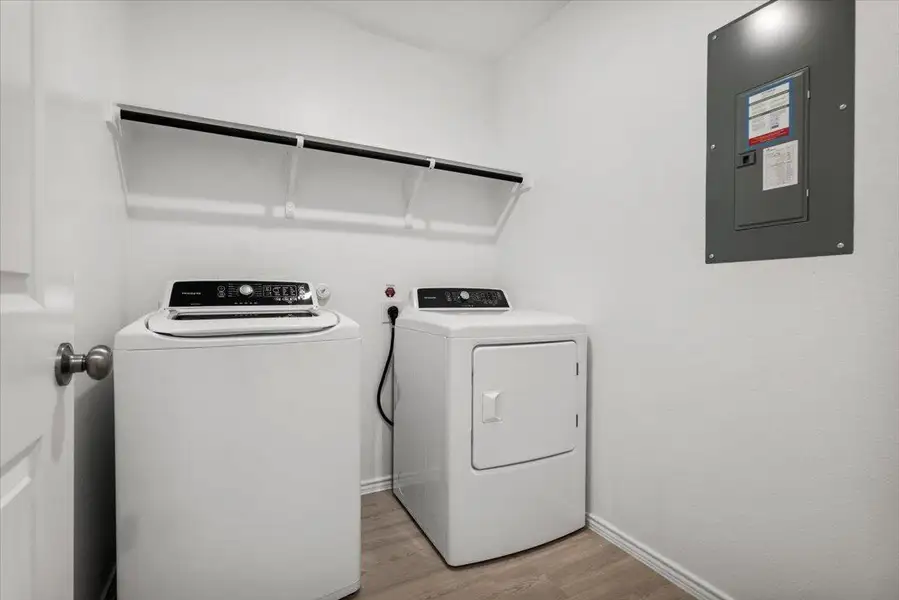 A dedicated laundry space provides practical convenience with overhead shelving and modern appliances. A dedicated laundry space provides practical convenience with overhead shelving and modern appliances.