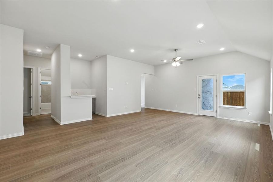 Unfurnished living room featuring recessed lighting, light wood-type flooring, a ceiling fan, and vaulted ceiling Unfurnished living room featuring recessed lighting, light wood-type flooring, a ceiling fan, and vaulted ceiling