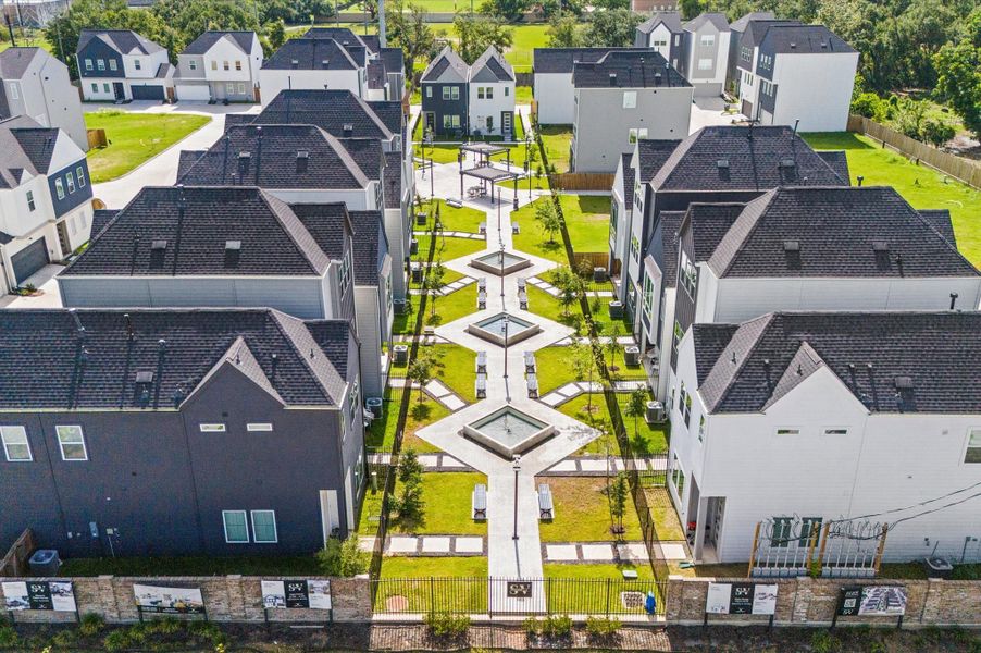 From above, Springwood Villas reveals its harmonious blend of architecture, greenery, and shared spaces. Homes are arranged in elegant rows, connected by winding pathways that lead to a central community courtyard—a lush oasis featuring pergolas, shaded seating, and water fountains.