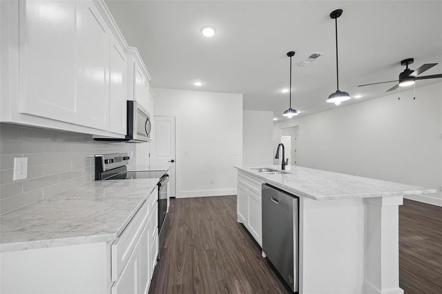 Kitchen with a sink, a ceiling fan, stainless steel appliances, visible vents, and dark wood-type flooring Kitchen with a sink, a ceiling fan, stainless steel appliances, visible vents, and dark wood-type flooring