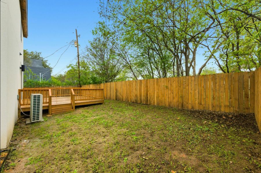 Fenced backyard featuring a wooden deck Fenced backyard featuring a wooden deck