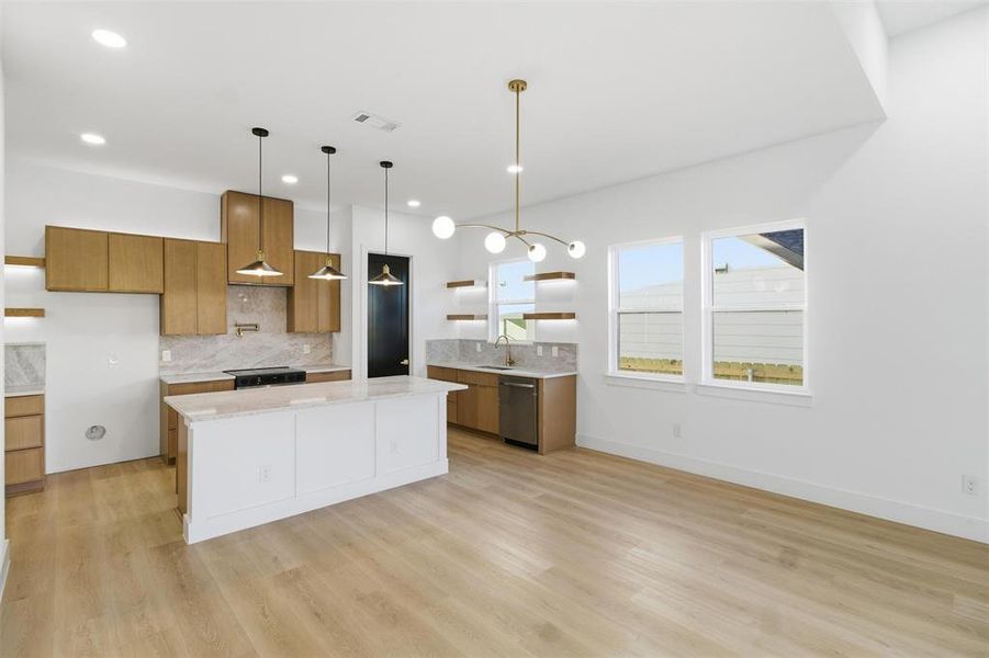 Kitchen with wood finish cabinets, open shelves, hanging light fixtures, and light stone countertops
