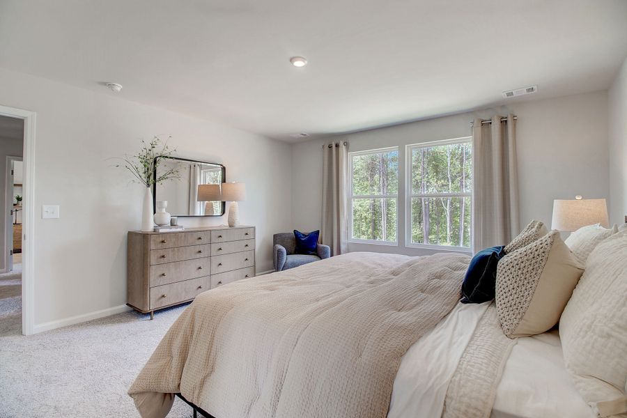 A large bedroom with a bed and a dresser.