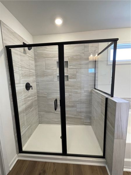 This sleek glass-enclosed shower features a tiled