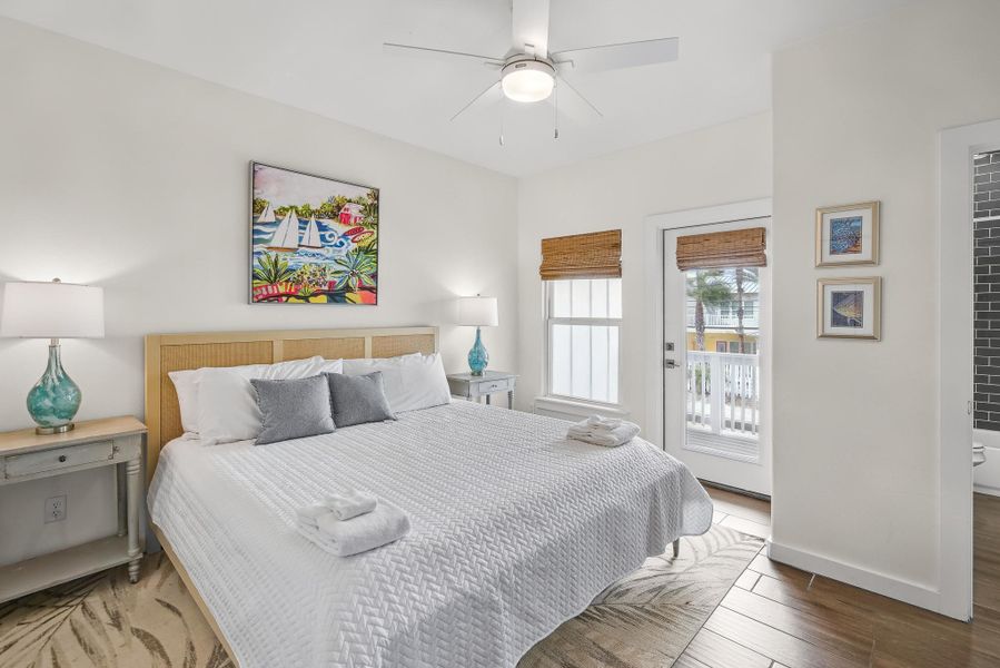 Bedroom with access to exterior, ceiling fan, and wood finished floors Bedroom with access to exterior, ceiling fan, and wood finished floors