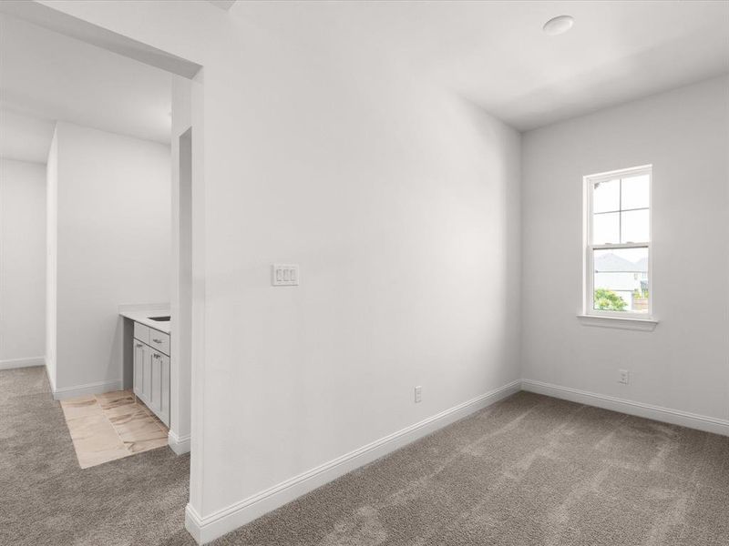 Spare room featuring light carpet and baseboards
