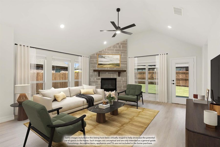 Living room with vaulted ceiling, stone fireplace, ceiling fan, and hardwood floors
