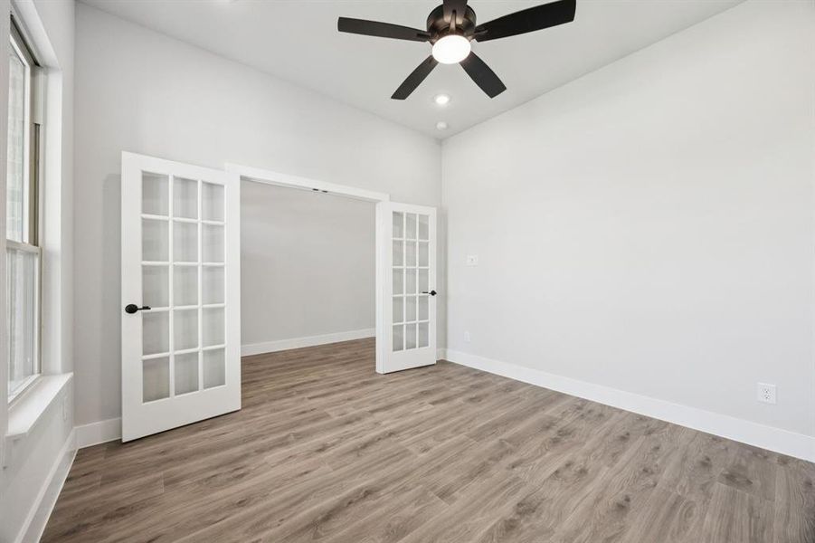 Spare room with french doors, wood finished floors, recessed lighting, and a ceiling fan