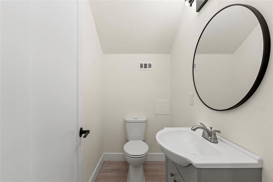 Half bathroom featuring wood finished floors and vanity Half bathroom featuring wood finished floors and vanity