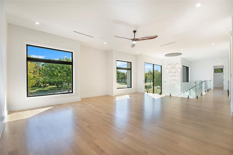 Unfurnished living room with healthy amount of natural light, recessed lighting, light wood-style floors, and a ceiling fan