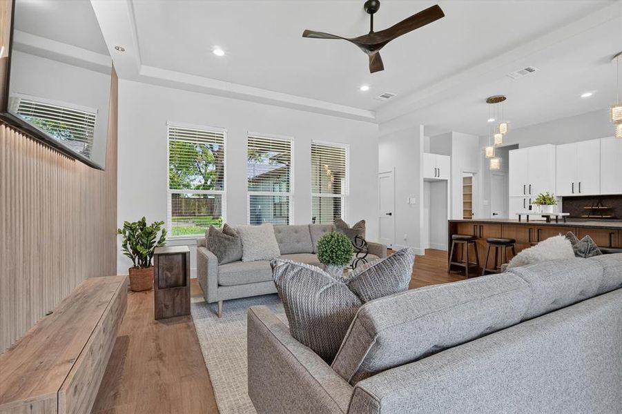Open-concept living space featuring wood-finish flooring, recessed lighting, and a contemporary ceiling fan