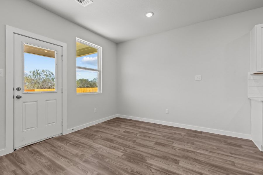 A room with white walls and a wood floor with a window. A room with white walls and a wood floor with a window.
