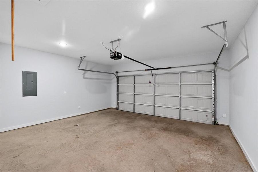 Garage featuring electric panel and a garage door opener Garage featuring electric panel and a garage door opener