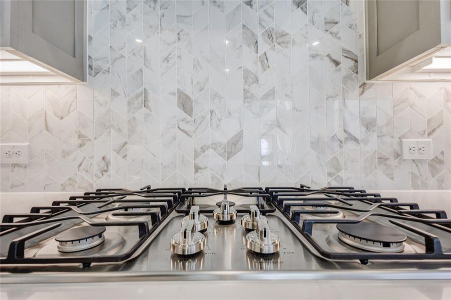 Room details featuring gas stovetop and decorative backsplash