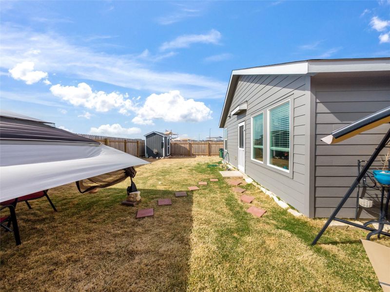 Fenced backyard with a storage shed