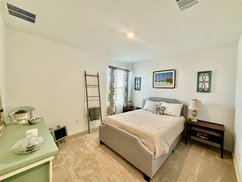 Bedroom with light colored carpet and baseboards