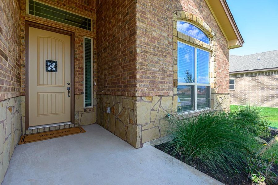 View of exterior entry with brick siding and stone siding View of exterior entry with brick siding and stone siding
