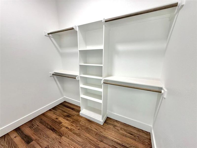 Walk in closet featuring dark wood finished floors Walk in closet featuring dark wood finished floors